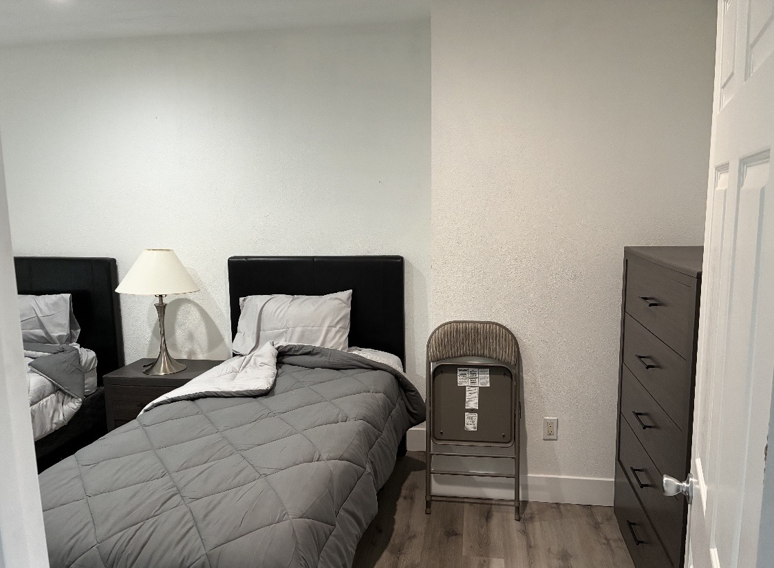 Private bedroom with a twin bed, nightstand, and dresser